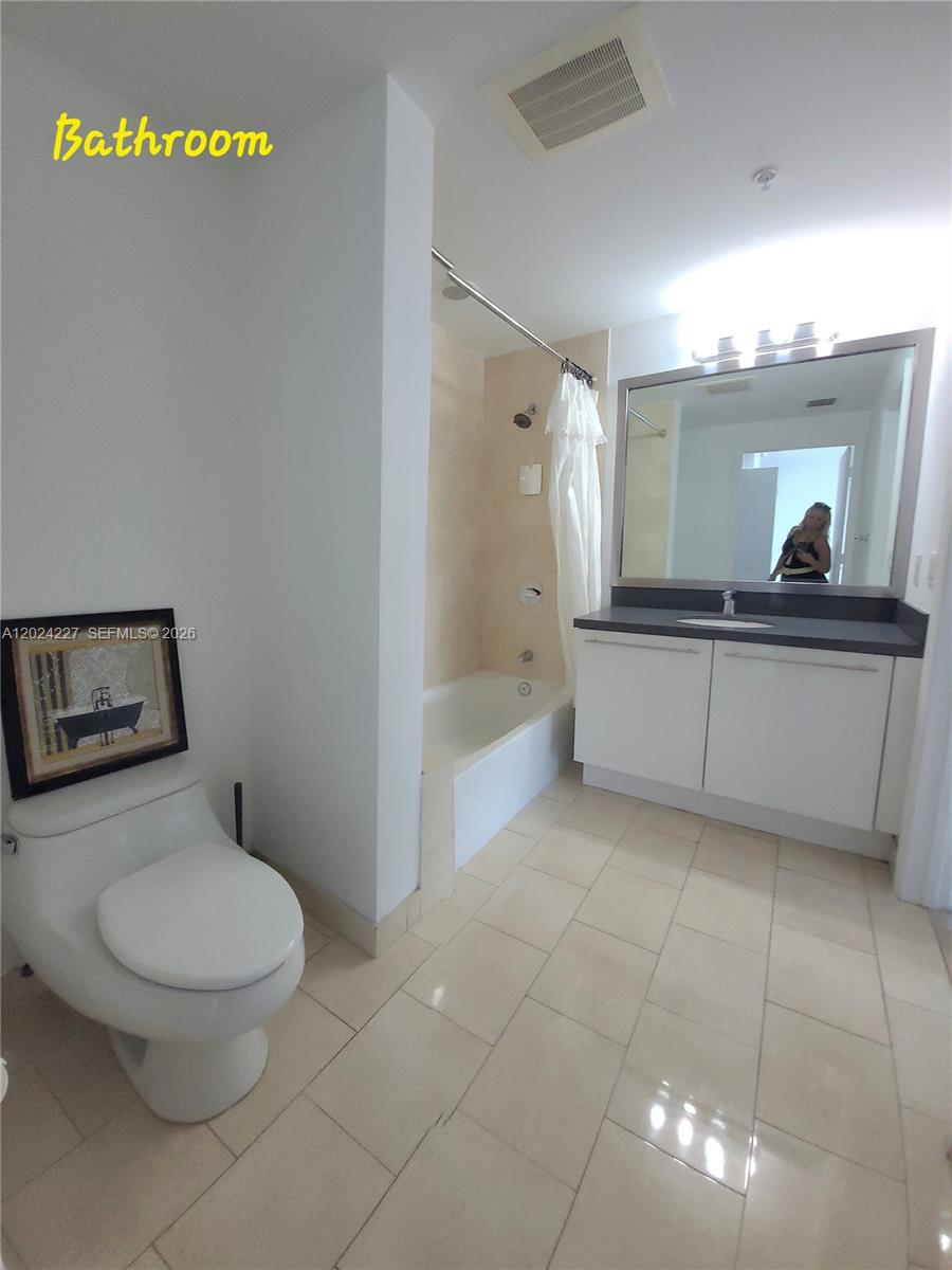 90 Southwest 3rd Street, Unit 2208 Miami, FL 33130 - Photo 21 of 56 a bathroom with a toilet a sink and mirror
