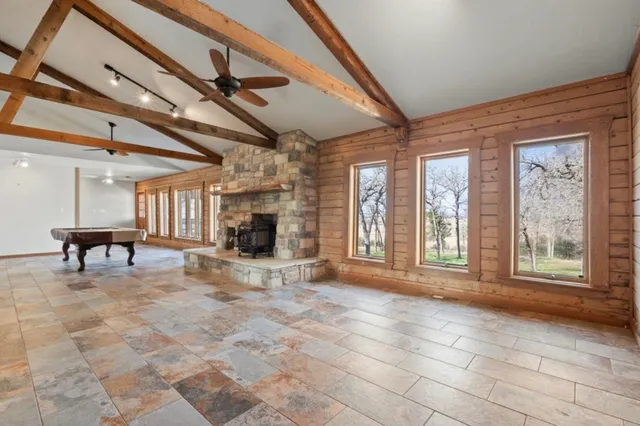 a view of an empty room with a fireplace and a window