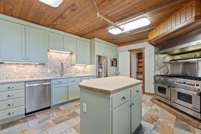 a kitchen with granite countertop cabinets stainless steel appliances and a counter space