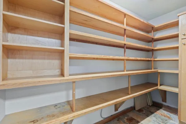 a view of walk in closet with empty racks