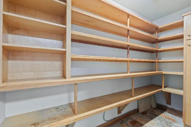 a view of walk in closet with empty racks