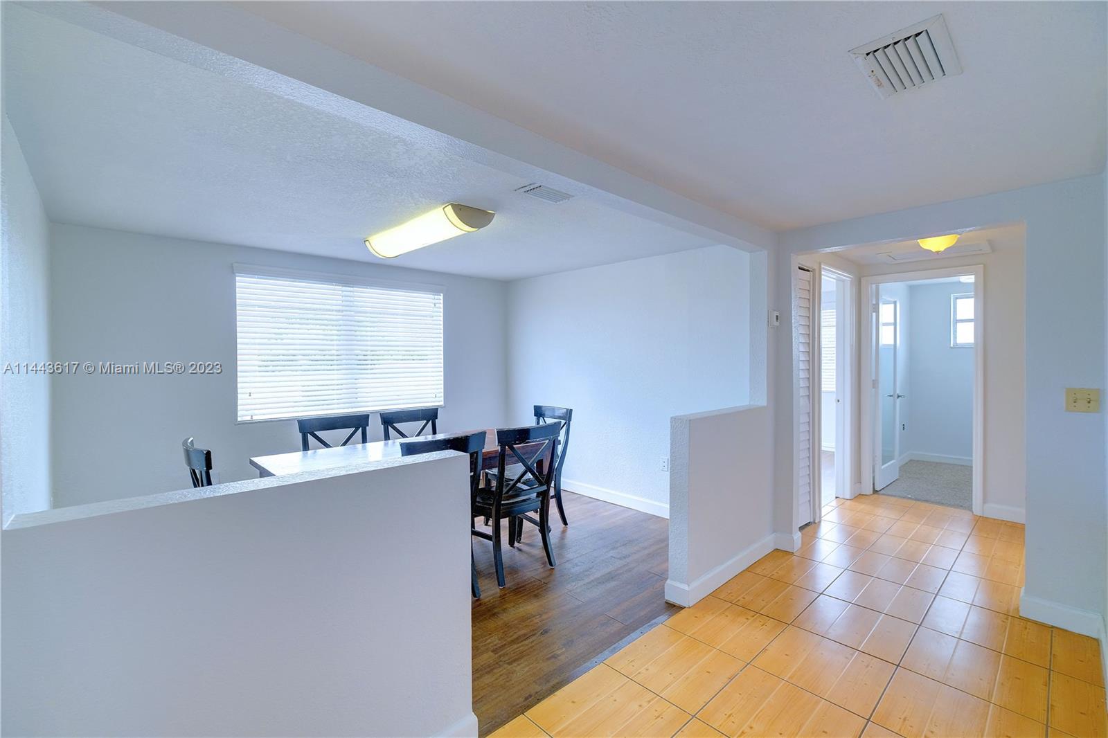 4640 Northwest 7th Street, Unit TOP Miami, FL 33126 - Photo 15 of 23 a view of a dining room with furniture window and wooden floor