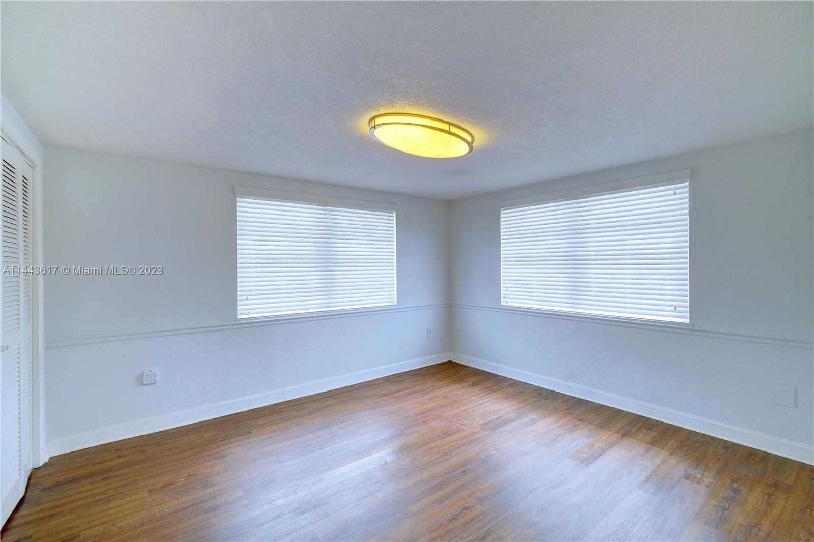 4640 Northwest 7th Street, Unit TOP Miami, FL 33126 - Photo 19 of 23 wooden floor in an empty room with a window