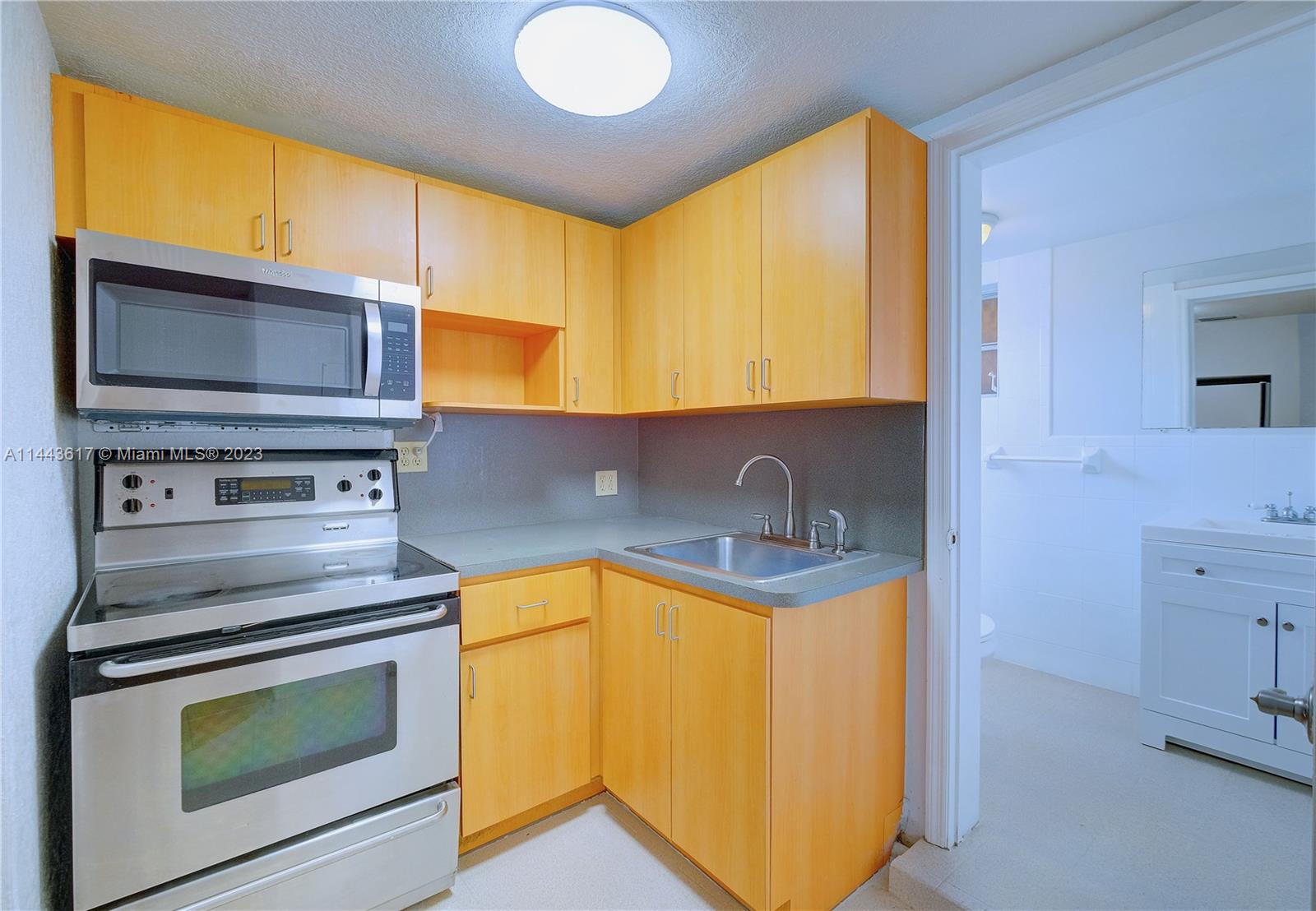 4640 Northwest 7th Street, Unit TOP Miami, FL 33126 - Photo 20 of 23 a kitchen with a sink stove and microwave