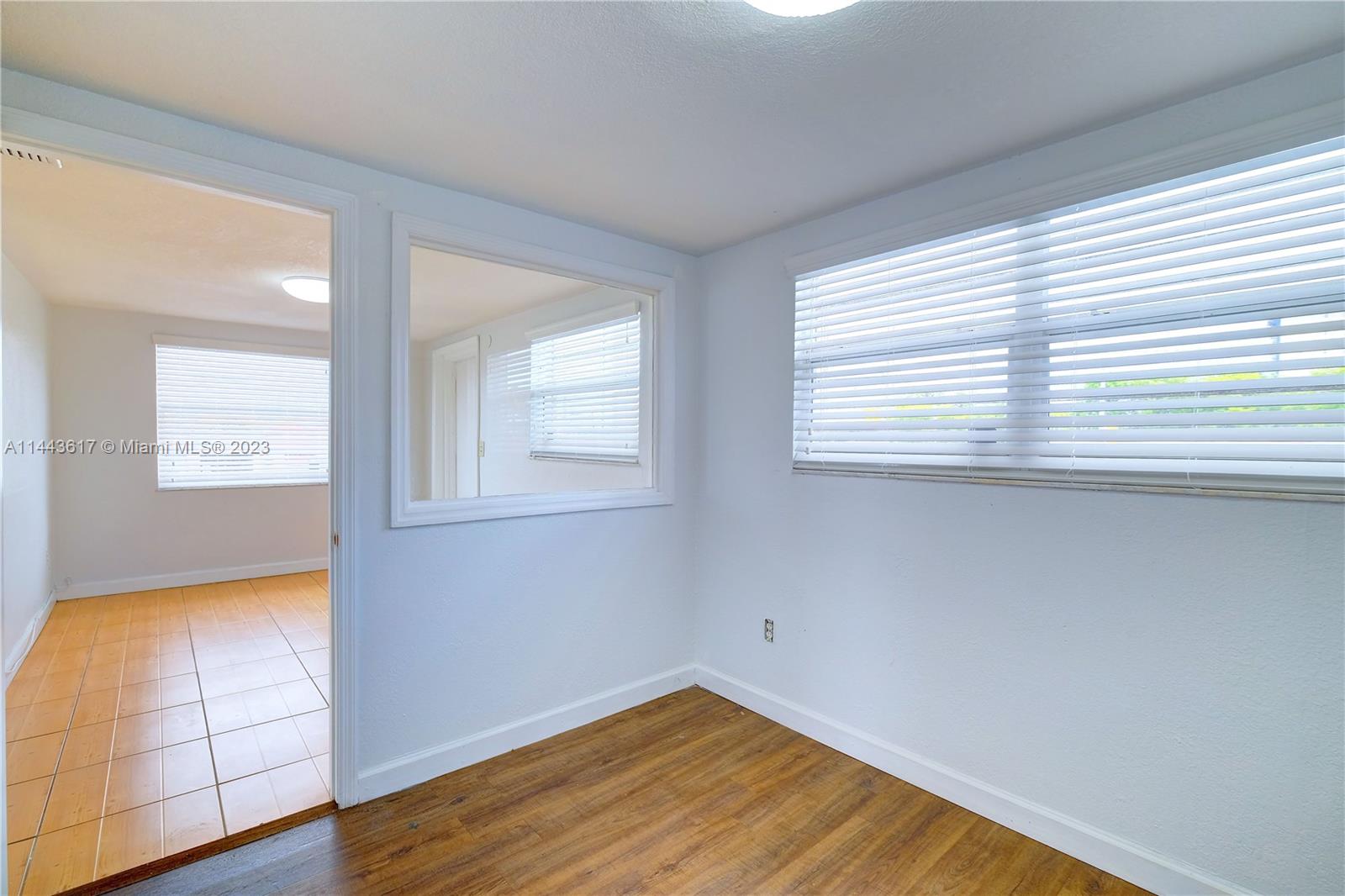 4640 Northwest 7th Street, Unit TOP Miami, FL 33126 - Photo 7 of 23 an empty room with wooden floor and windows