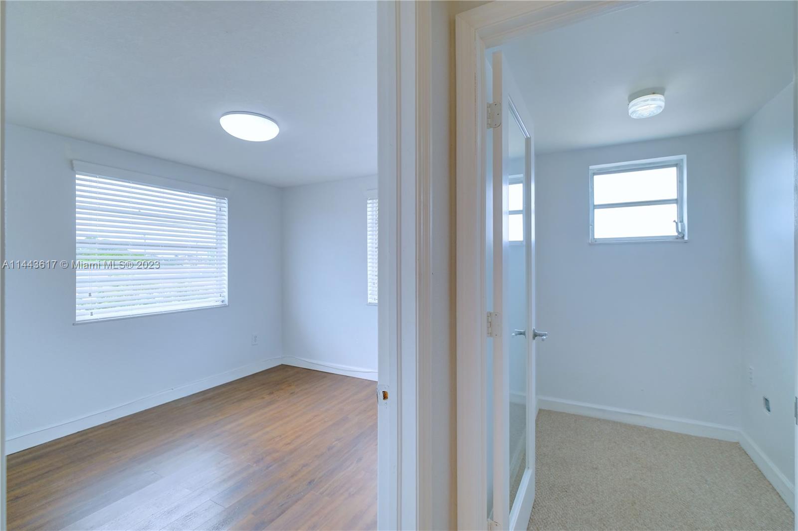 4640 Northwest 7th Street, Unit TOP Miami, FL 33126 - Photo 9 of 23 a view of an empty room with wooden floor and a window