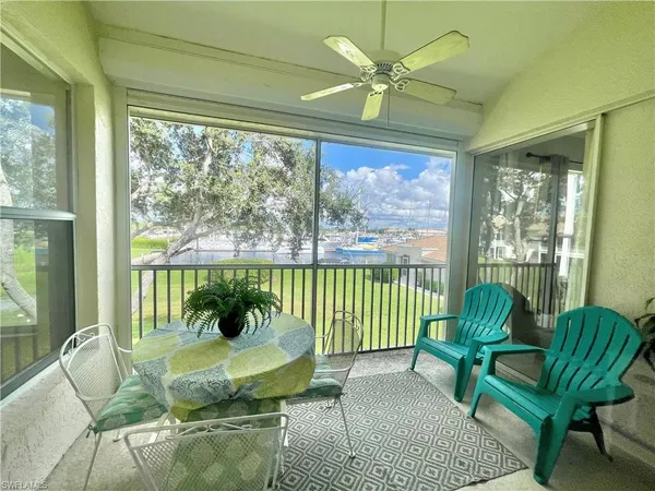 a living room with furniture a flat screen tv and a large window