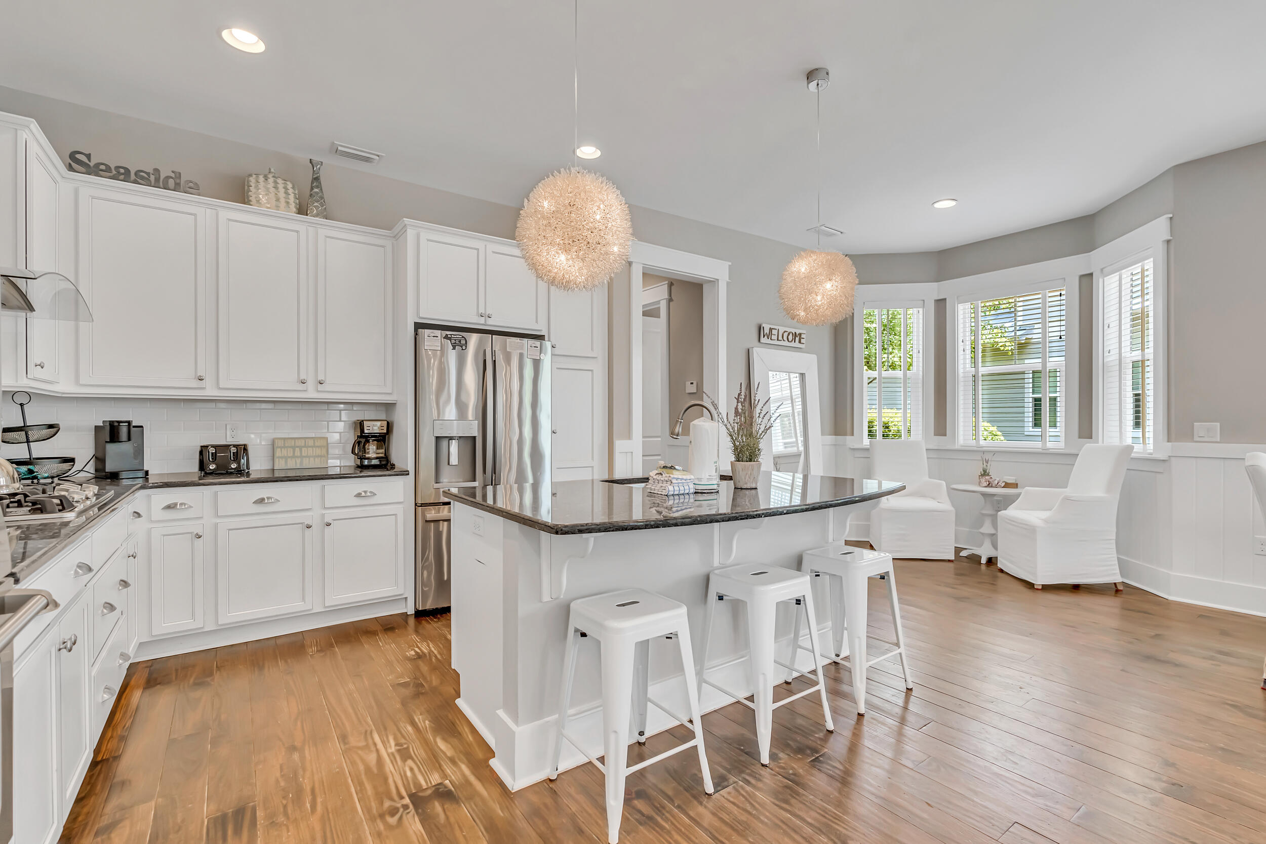 679 Flatwoods Forest Loop Santa Rosa Beach, FL 32459 - Photo 12 of 46 a kitchen with stainless steel appliances granite countertop a stove top oven a sink dishwasher and white cabinets with wooden floor