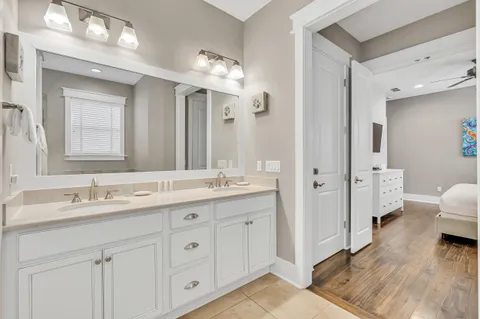 a spacious bathroom with double vanity a mirror and a shower