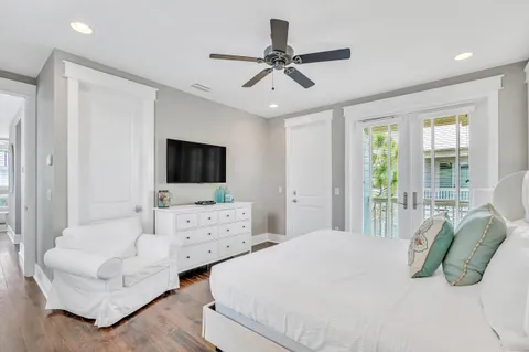 a bedroom with a bed a flat screen tv and couches