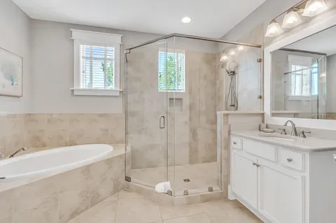 a bathroom with a granite countertop bathtub shower sink and mirror