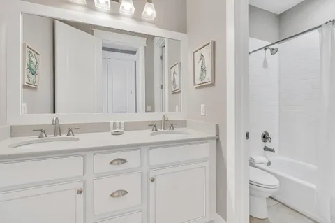 a bathroom with a granite countertop sink a toilet and a bathtub