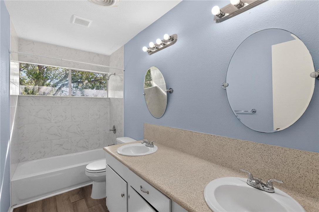 1104 Polaris Drive Portland, TX 78374 - Photo 20 of 39 a bathroom with a granite countertop toilet a sink and a mirror