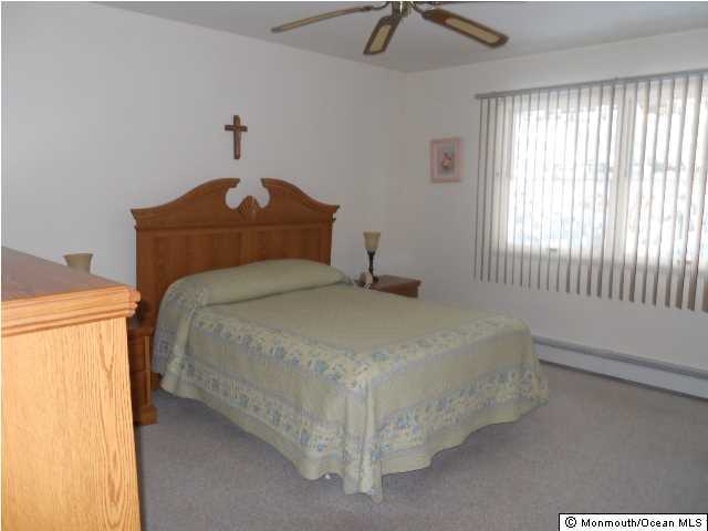 19 Oakfield Road Toms River, NJ 08757 - Photo 9 of 15 a bedroom with a bed and a chandelier
