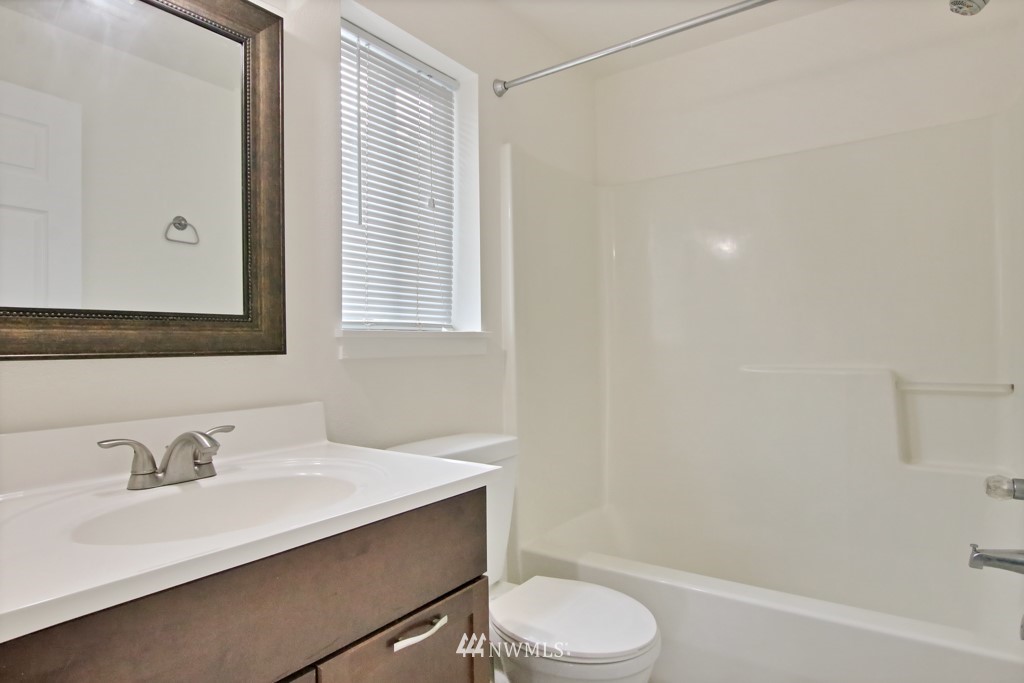 15925 Spanaway Loop Road South Spanaway, WA 98387 - Photo 4 of 14 a bathroom with a sink toilet a mirror and shower
