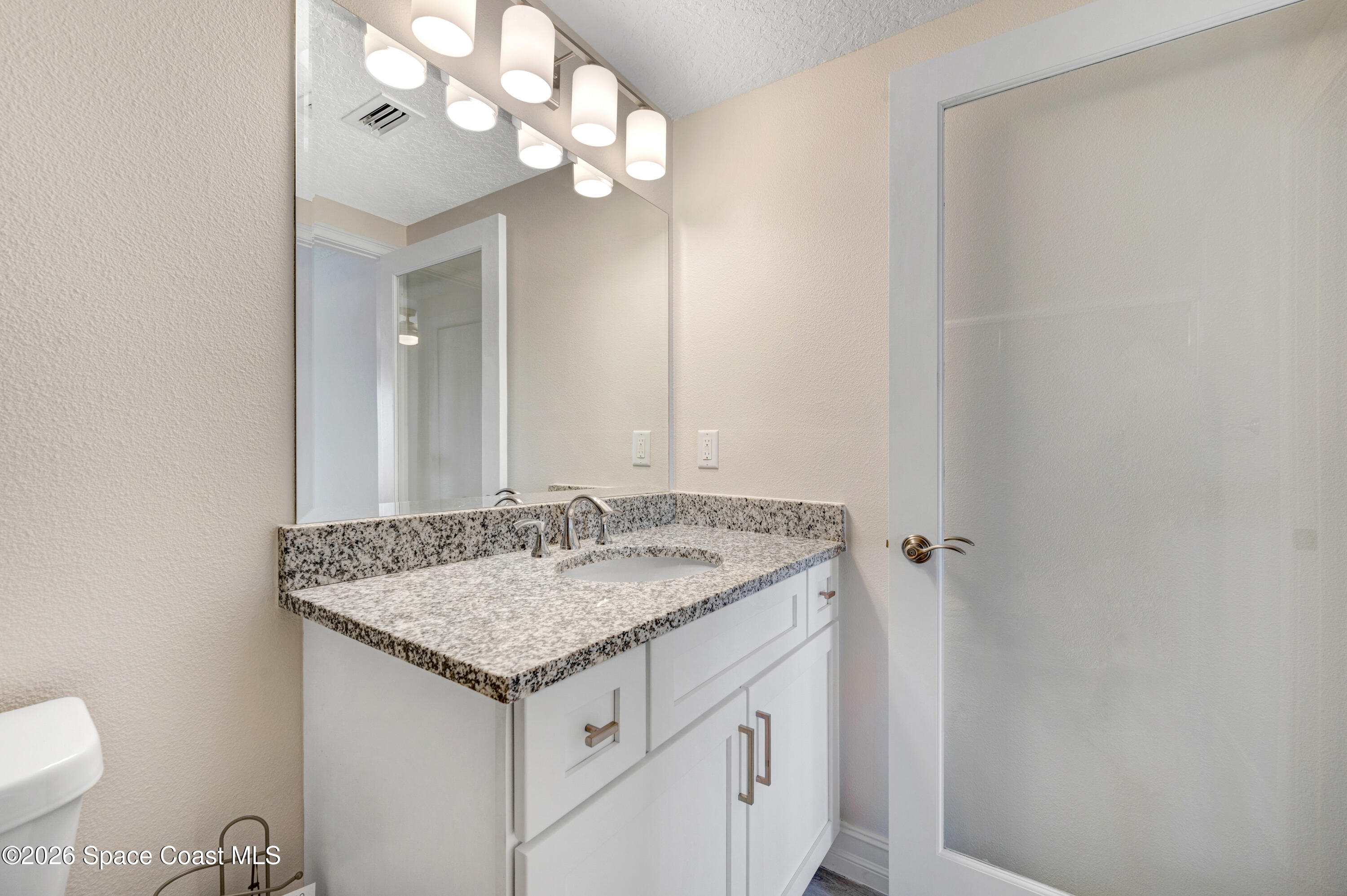 1805 Riverside Drive, Unit 304 Titusville, FL 32780 - Photo 19 of 46 a bathroom with a granite countertop sink and a mirror