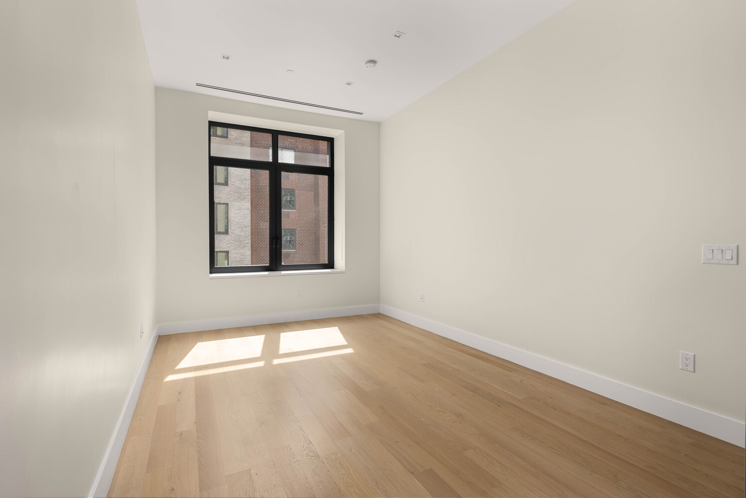435 West 19th Street, Unit 4A Manhattan, NY 10011 - Photo 3 of 9 an empty room with wooden floor and windows