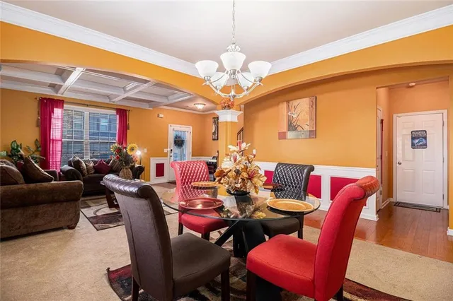 a view of a dining room with furniture a chandelier and wooden floor