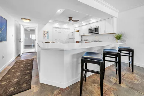 a kitchen with stainless steel appliances granite countertop table chairs sink and cabinets