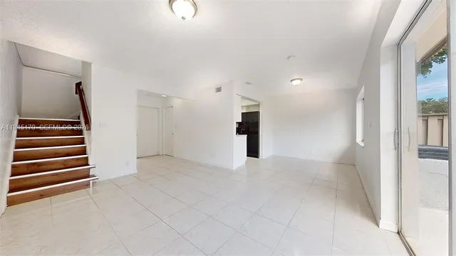 an empty room with stairs and windows