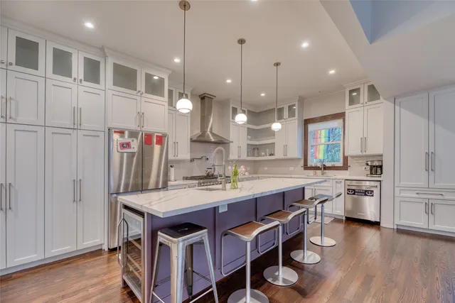 a kitchen with kitchen island a large counter top space a sink stainless steel appliances and cabinets