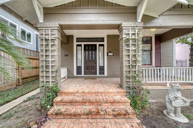 a front view of a house with a yard and potted plants