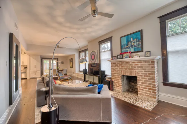 a dining room with wooden floor and large windows
