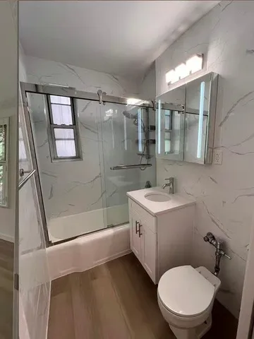 a bathroom with a sink a toilet and shower