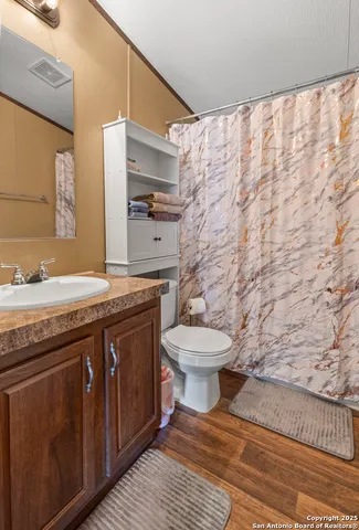 a bathroom with a granite countertop toilet sink and mirror