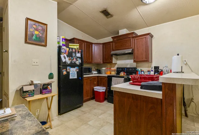 a kitchen with stainless steel appliances granite countertop a refrigerator and a sink