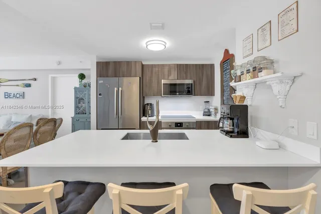 a kitchen with a table chairs refrigerator and microwave