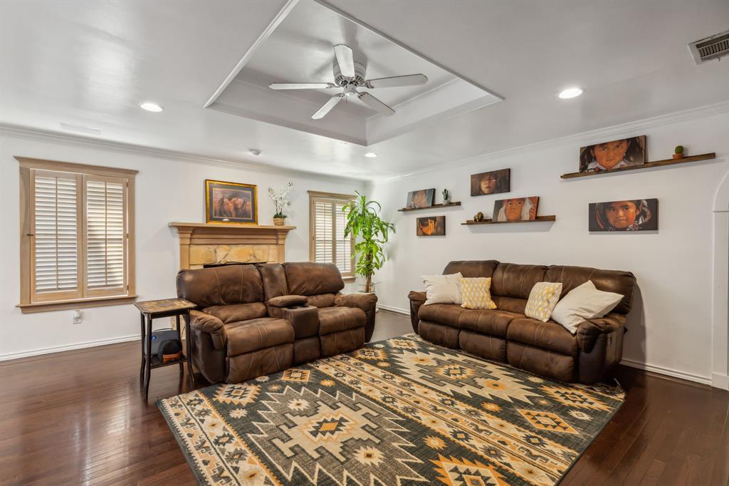 1980 Winningkoff Road Lucas, TX 75002 - Photo 19 of 35 Spacious living area featuring dark wood-finish flooring and a tray ceiling with a ceiling fan