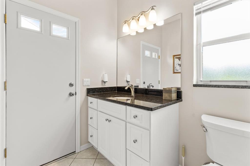 1802 North Musial Point Hernando, FL 34442 - Photo 25 of 42 a bathroom with a granite countertop sink a toilet and a mirror