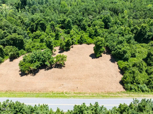 an aerial view of residential house with outdoor space and trees all around