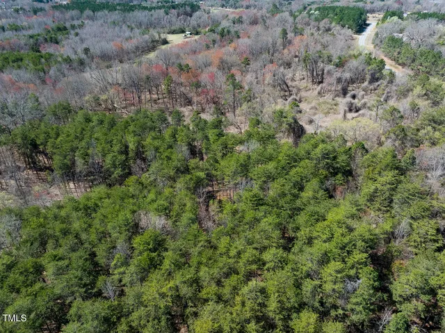 an aerial view of residential house with outdoor space and trees all around