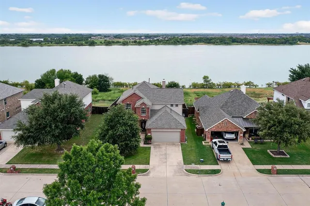 an aerial view of a house with outdoor space and lake view in back