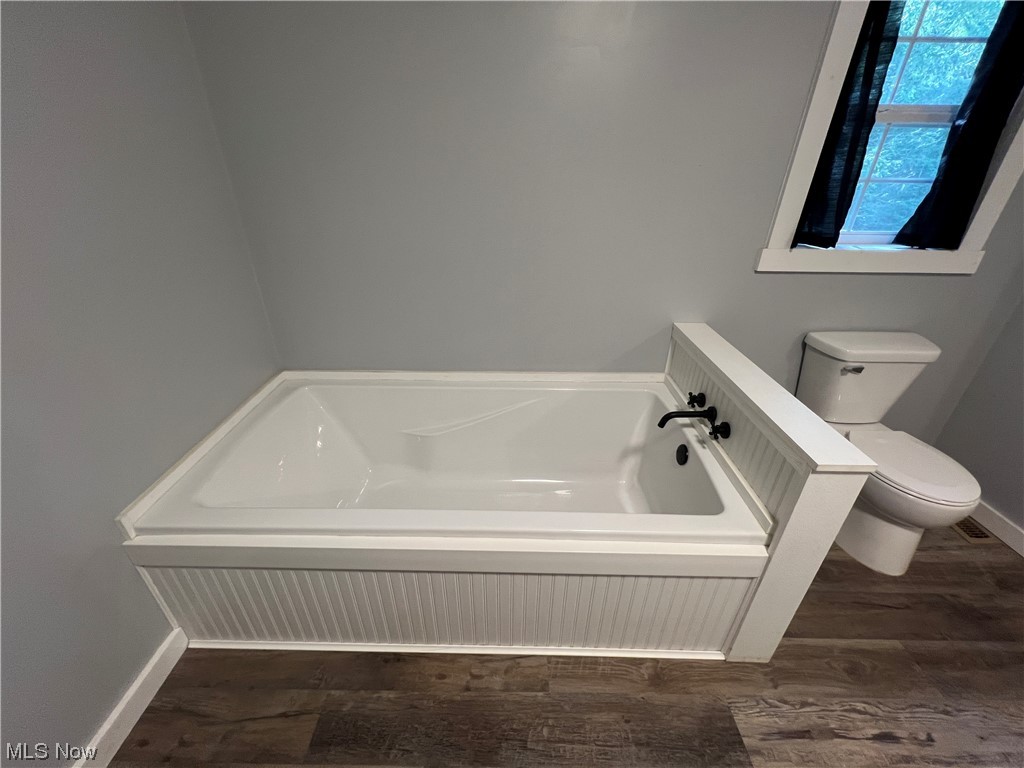 6544 Middle Run Road Dover, OH 44622 - Photo 13 of 47 Bathroom with wood-type flooring, a tub, and toilet