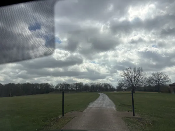 a view of a pathway with a yard in back