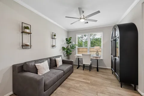 a living room with furniture and a wooden floor