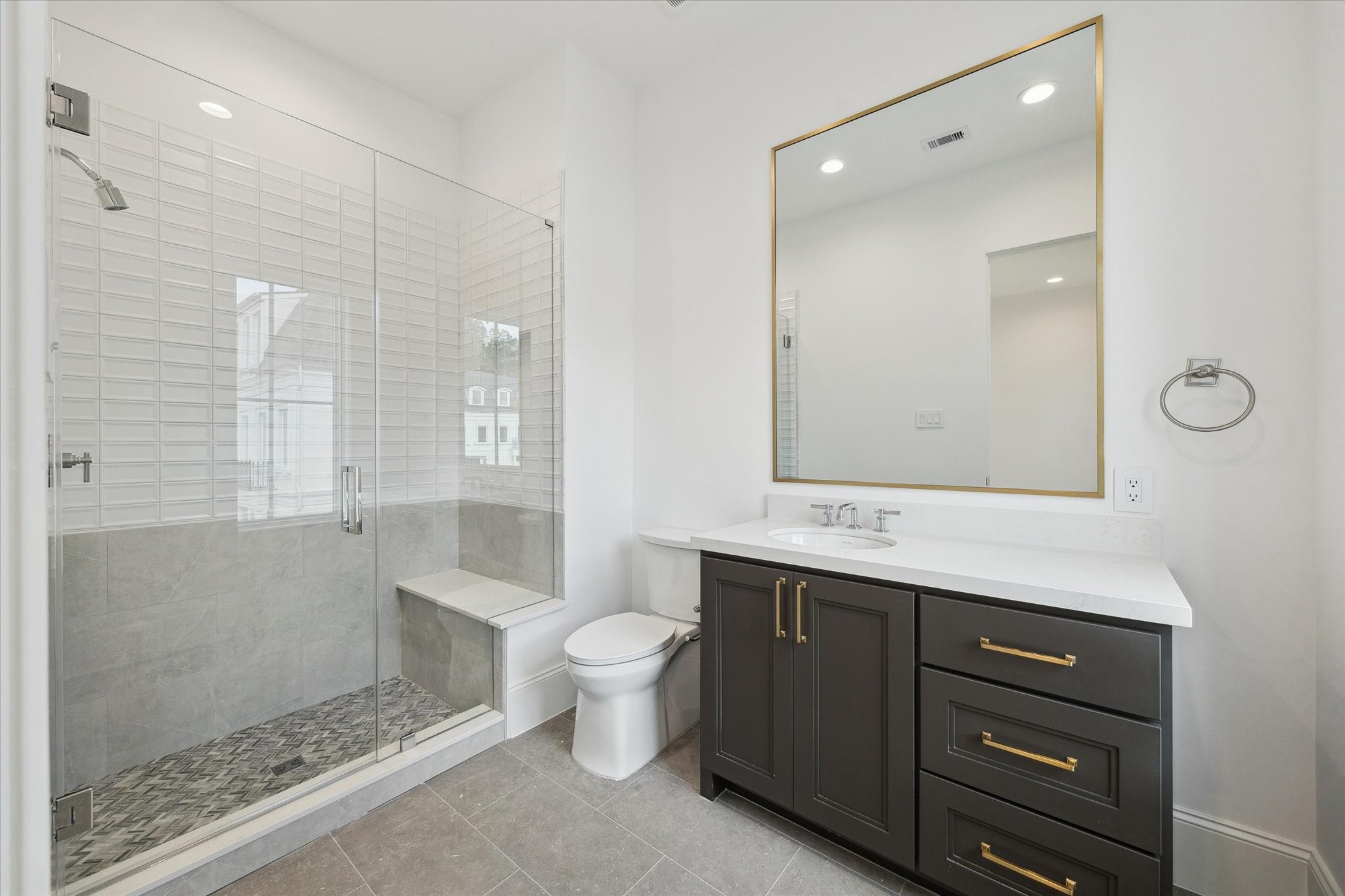 25 Wentworth Gate Path Houston, TX 77027 - Photo 23 of 32 En-suite bathroom features a sleek, glass-encased shower, Quartz counters and additional counter and storage space.