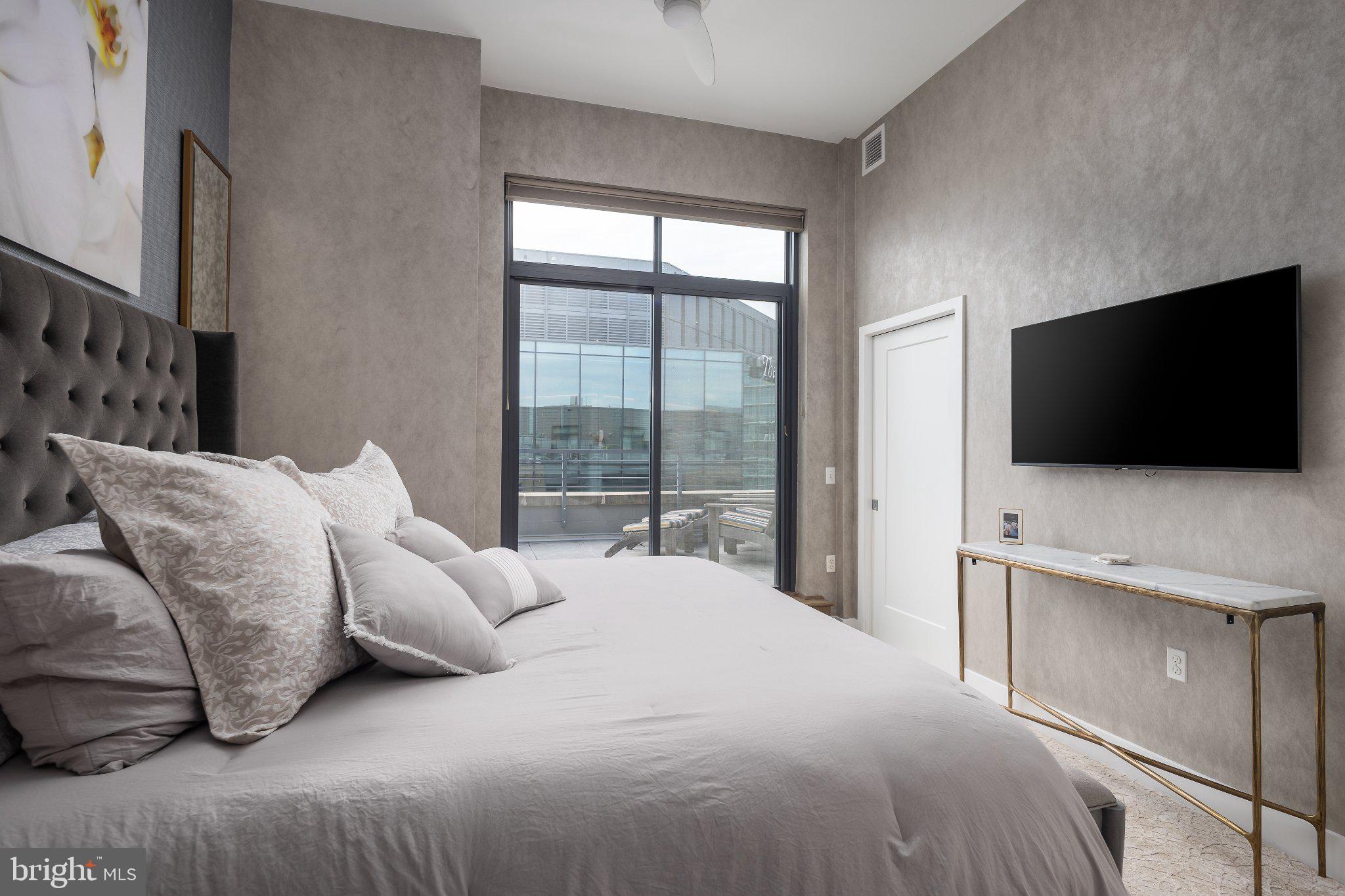 525 Southwest Water Street Southwest, Unit 404 Washington, DC 20024 - Photo 12 of 82 a bedroom with a bed and a flat screen tv