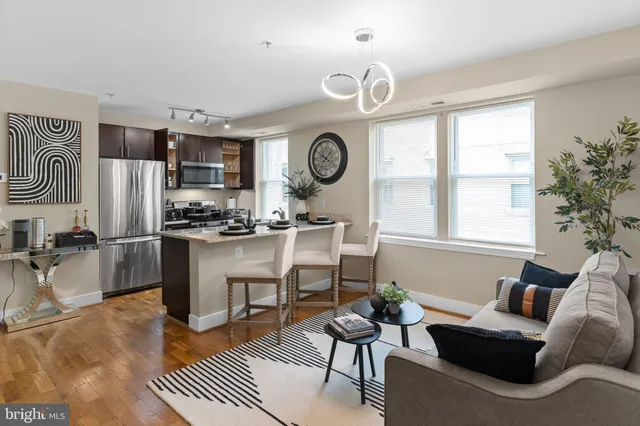 a living room with furniture a large window and kitchen view