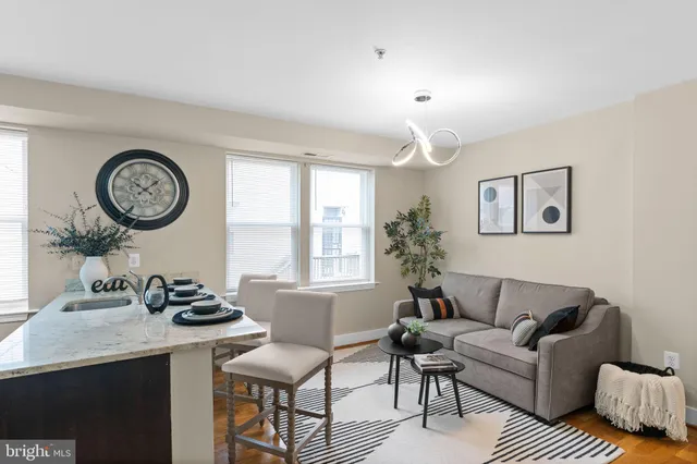 a living room with furniture a clock and wall paintings