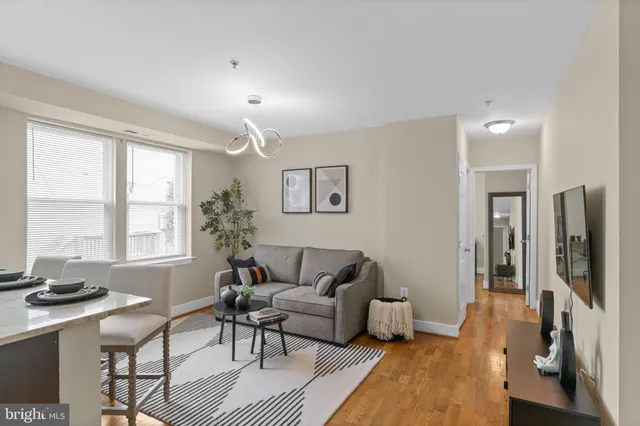 a living room with furniture a window and a flat screen tv