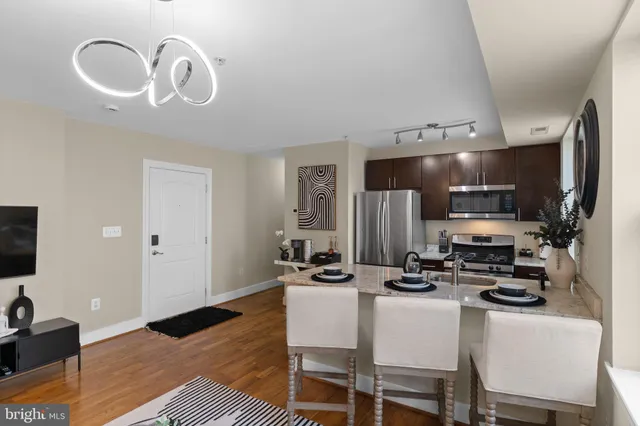a kitchen with stainless steel appliances kitchen island granite countertop a sink and cabinets