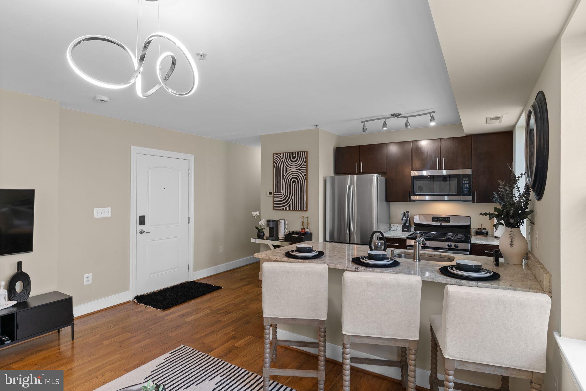 417 18th Street Northeast, Unit 104 Washington, DC 20002 - Photo 23 of 40 a kitchen with stainless steel appliances kitchen island granite countertop a sink and cabinets