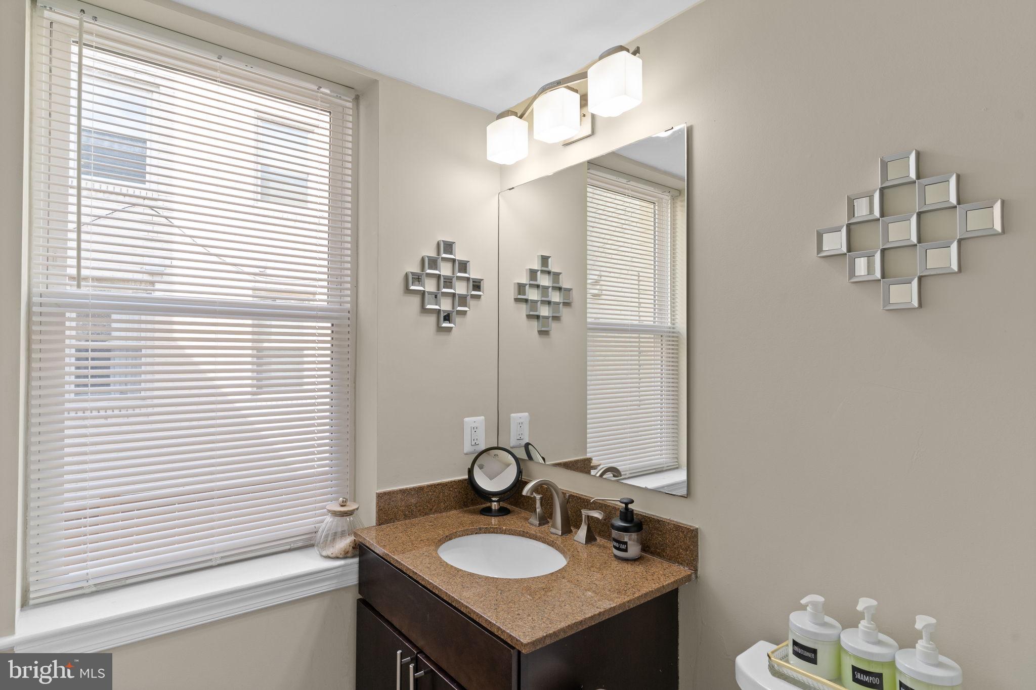 417 18th Street Northeast, Unit 104 Washington, DC 20002 - Photo 29 of 40 a bathroom with a sink a mirror and a window
