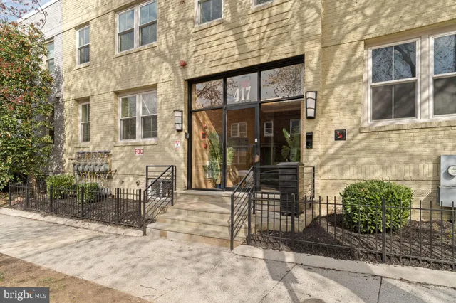 a view of a brick building with a bench in front of building