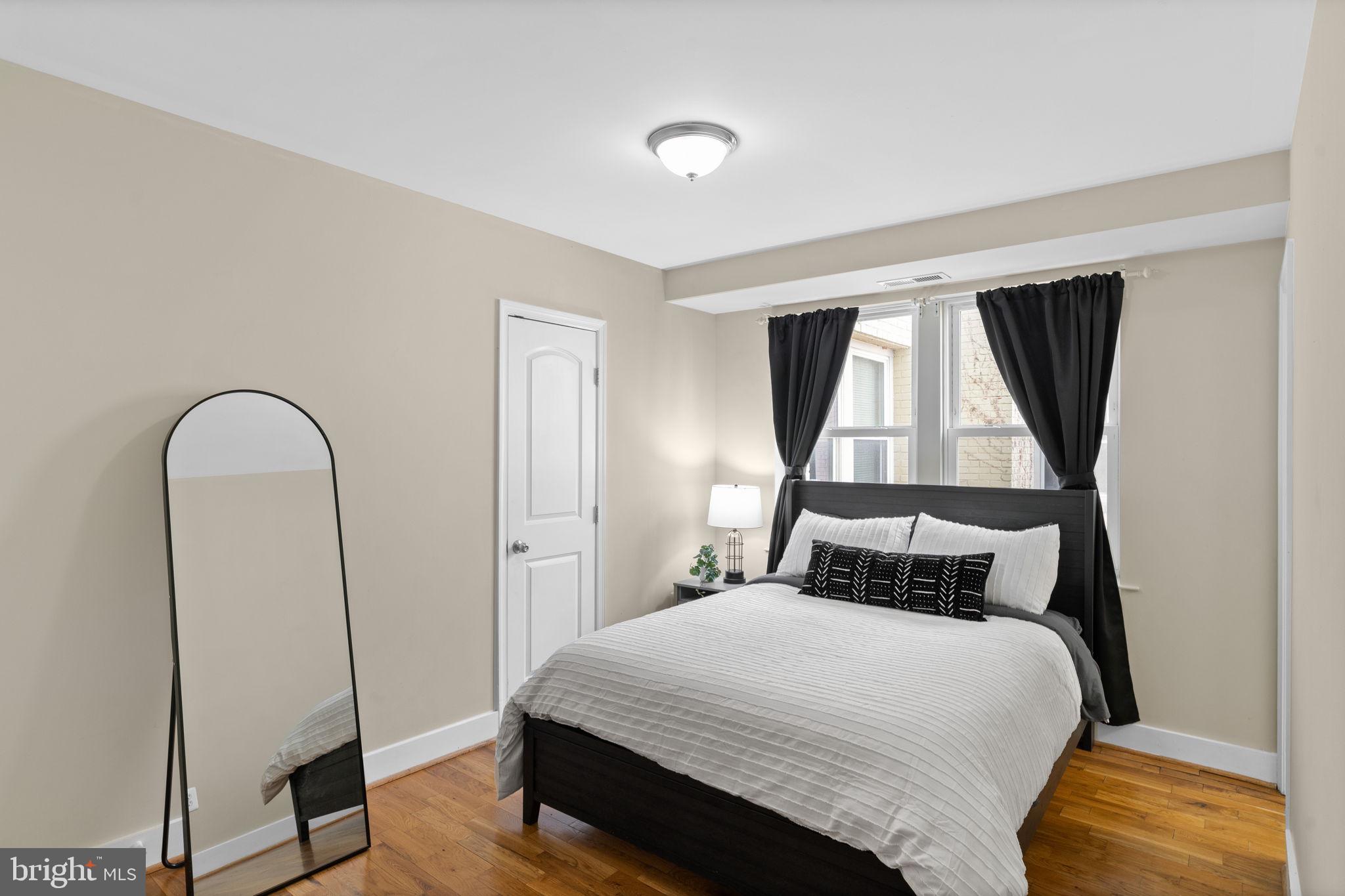 417 18th Street Northeast, Unit 104 Washington, DC 20002 - Photo 33 of 40 a bedroom with a bed and wooden floor