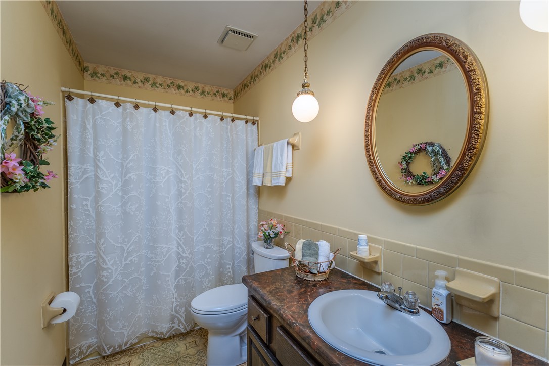 4210 Pleasanton Road Englewood, OH 45322 - Photo 24 of 34 This bright bathroom features a vanity, shower, and toilet, offering both style and essential amenities.